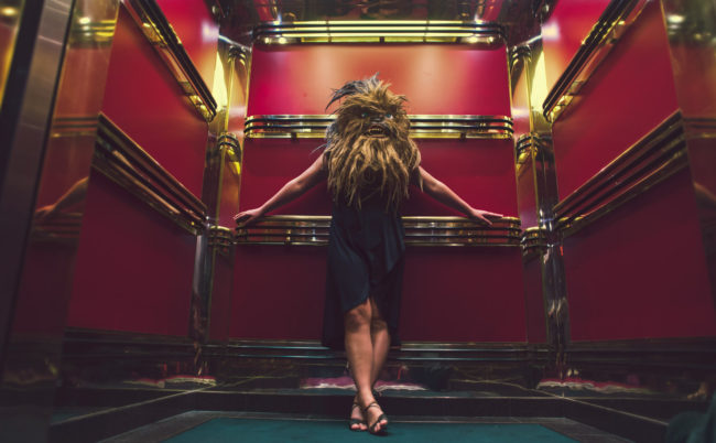 Mary Celeste V Photograph by Mako Miyamoto. Wookie woman standing in a red and gold elevator on a cruise ship