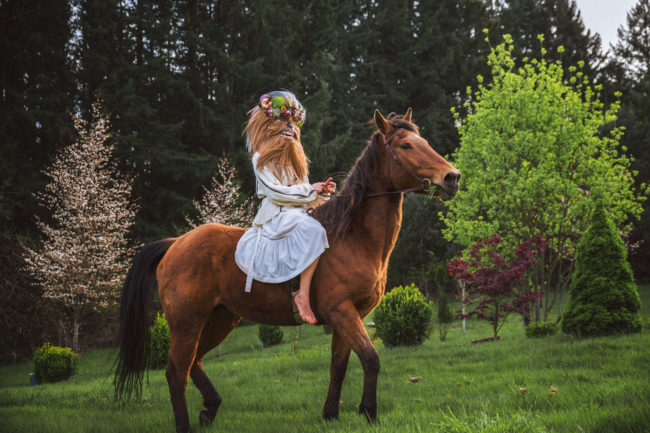 Crystal Visions III Photograph by Mako Miyamoto. Wookie in a white dress and flowers in her hair riding a horse through a magical field