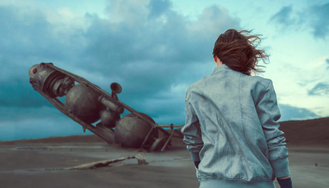 The Coast II Photograph by Mako Miyamoto. Girl walking on the oregon coast with a crashed spaceship in the sand in the background. Created for the series Further West shown at Stephanie Chefas Gallery in Portland, OR